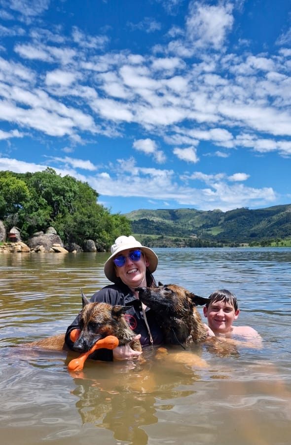 Marilé swimming in the river with two of the dogs